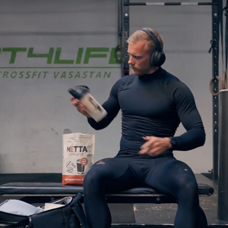 A 30 year old athlete, preparing a caffe latte MËTTA shake at the gym. 
