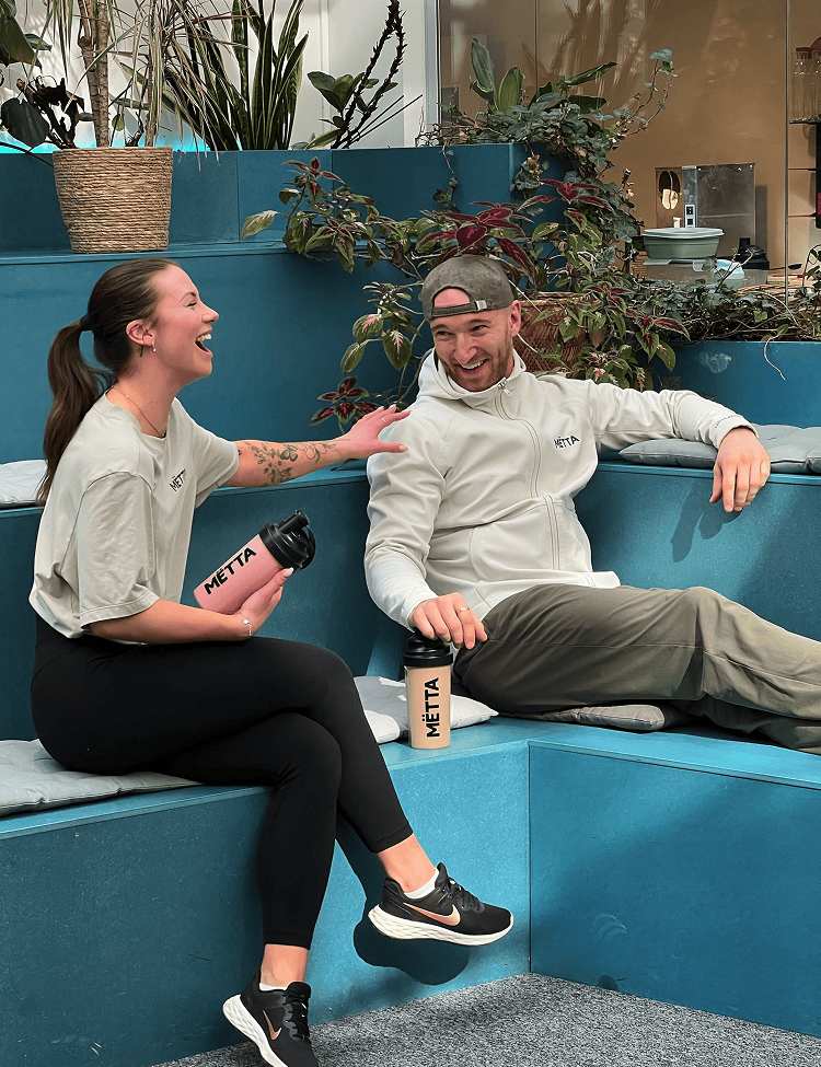 A 30 year old man & woman talking while enjoying a MËTTA food shake.