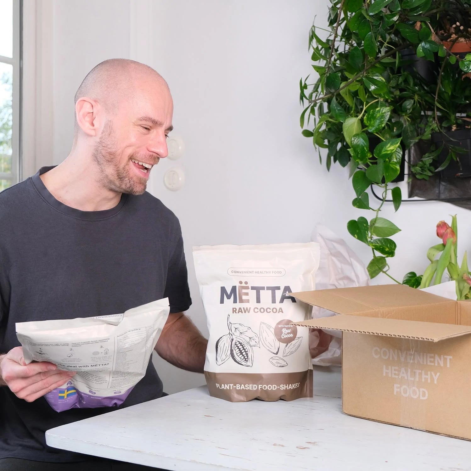 a 35 year old man unboxing MËTTA package. Featuring a raw cocoa & smoothiebowl food shake large bags.