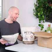 a 35 year old man unboxing MËTTA package. Featuring a raw cocoa & smoothiebowl food shake large bags.